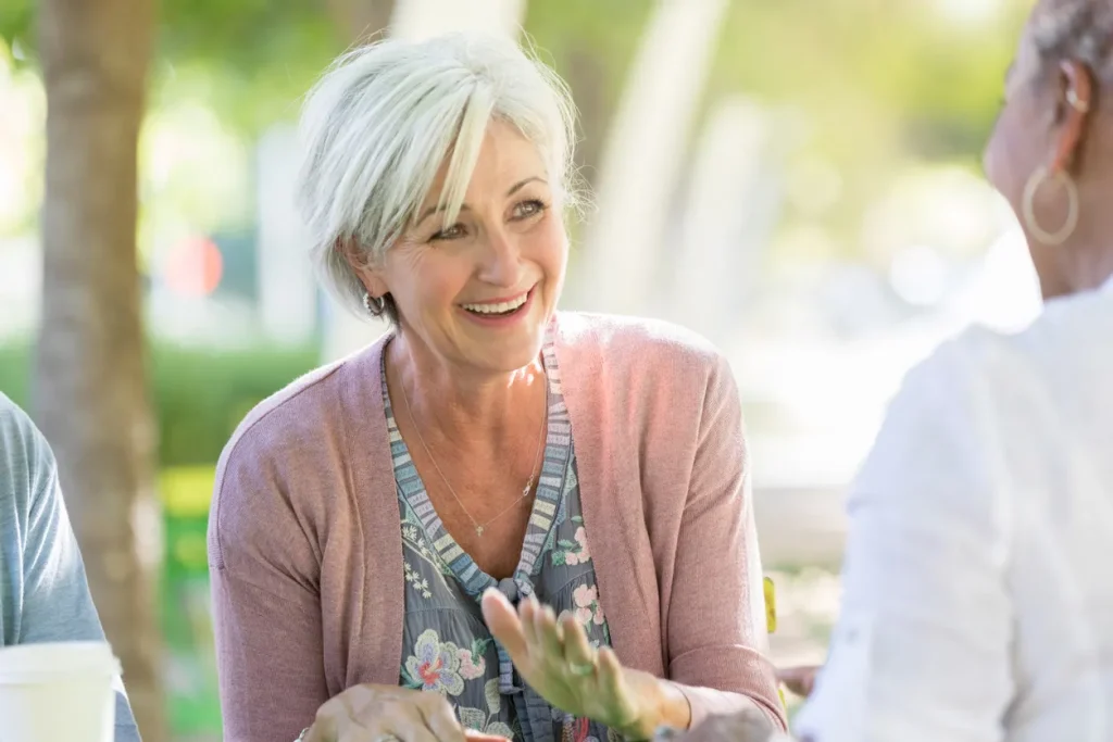 Older woman sharing her story with friends, illustrating the community and support in sharing personal experiences with our compounded anti-inflammatory medication.